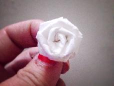 用手帕纸的六分之一粗折一朵玫瑰花。