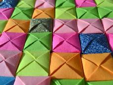 用不同颜色的纸条或彩色胶带折出不同颜色的小方块，通过拼贴来装饰
