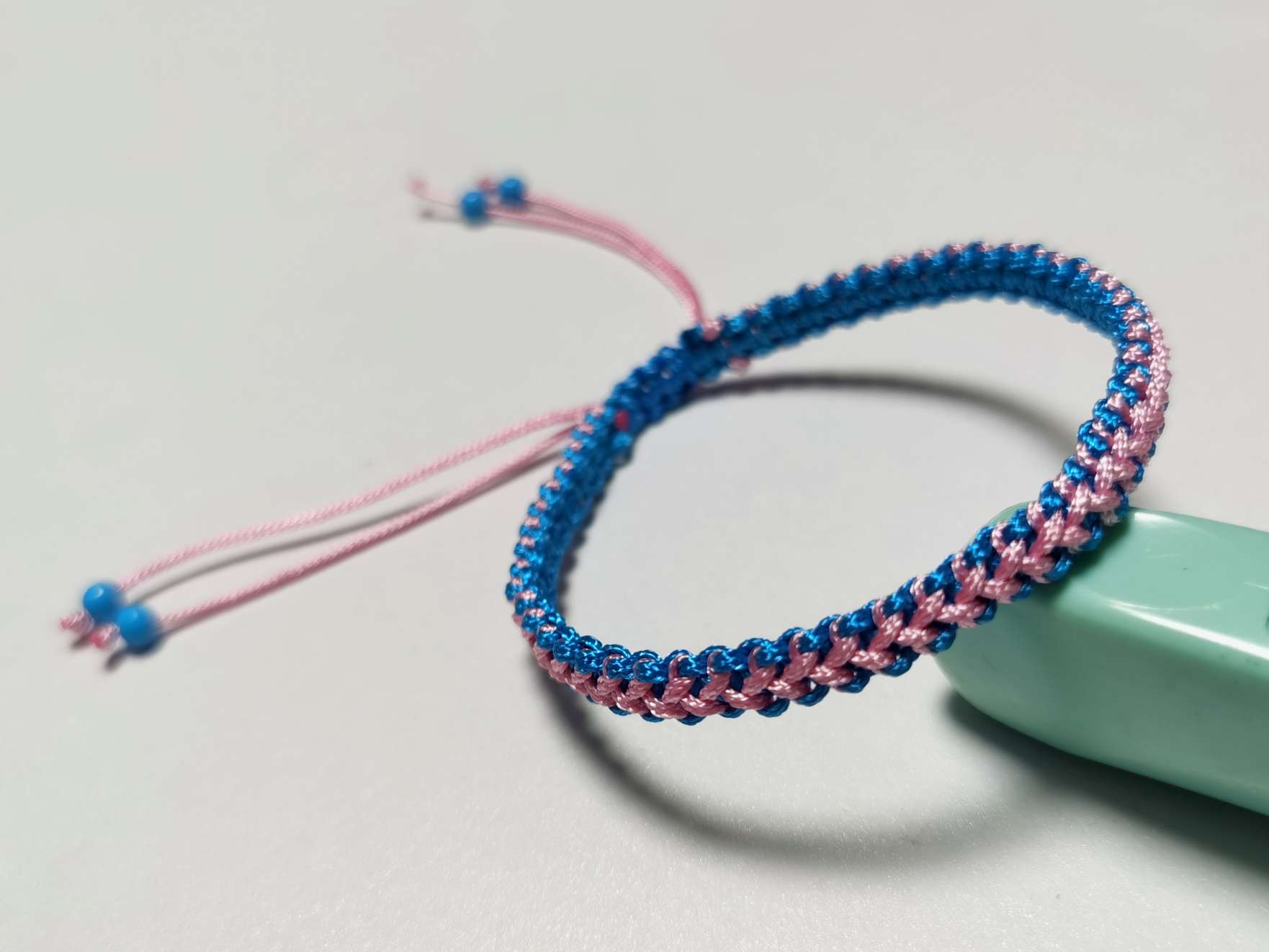 这款手链用平结做基础结，加线编织而成。