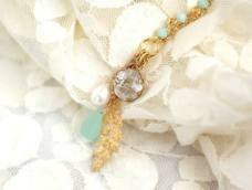 金黄色链条与碧绿色的珠子，作为主体，暖色调中穿插着冷色调，有一种简约的美。