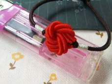 红色的曼陀罗花结配上咖啡色细款手绳，却也别有一番风味。