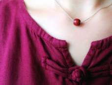 简单的红檀点缀在颈间，如朱砂痣一般