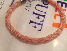 米色黄色粉色蜡线编的，很细很精致，我很喜欢，就是没有好的扣头，用的垃圾扣头，估计戴2天就黑了，现在颜色已经有点暗了^_^