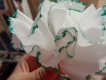 用纸巾对折几次再对折，在两边涂上颜色，然后中间一条折痕对上一条绳子。再把餐巾纸分层。