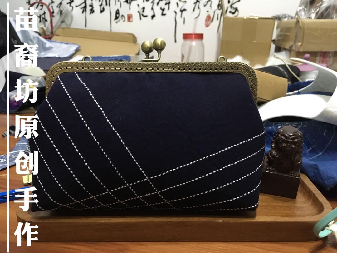  这款包包是绣在贵州特有的蓝靛土布上的，只有一针一线才合适这种用心制作的土布，贵州高原的有机板蓝根侵染的手工土布散发出来轻轻香气