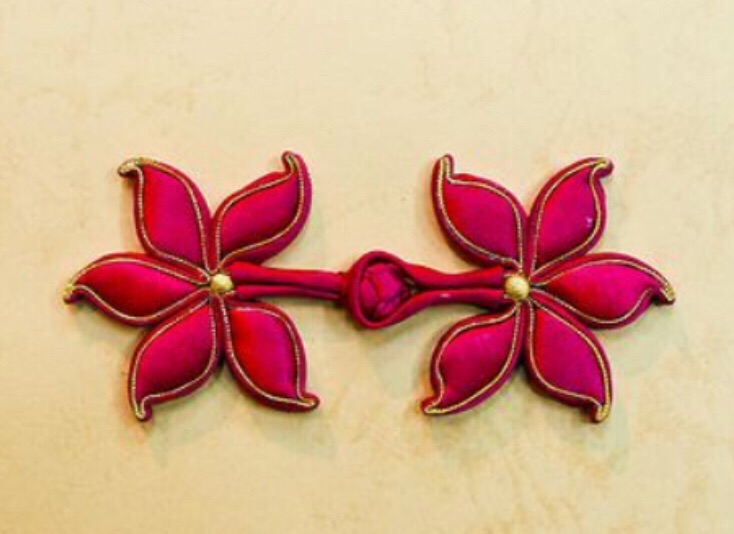 旗袍的扣子分软扣和硬扣两种，制作工艺不同。扣子是旗袍中的点睛之笔，在颜色的搭配和花型的设计上需要特别考究，是不容忽视的重要一环。