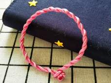 最简单的手绳只需要一根股线就能编出来，就是用两股辫拧麻花编织，素绳可以直接佩戴，也能串上好看的转运珠，成本还不到一块钱。